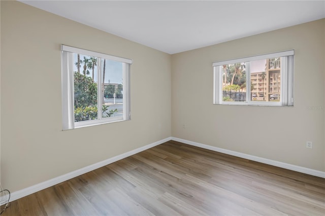 empty room with light wood finished floors and baseboards