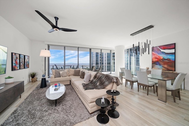 living room featuring expansive windows, ceiling fan, and light hardwood / wood-style floors