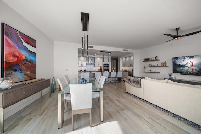 dining space featuring ceiling fan and light wood-type flooring