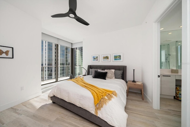 bedroom featuring ceiling fan, ensuite bathroom, and light hardwood / wood-style flooring