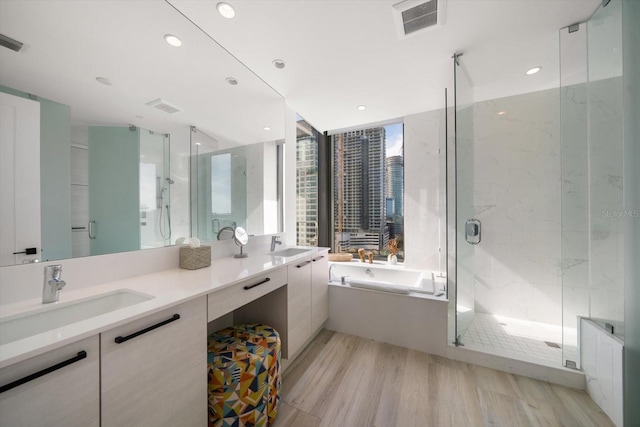 bathroom with vanity, wood-type flooring, and shower with separate bathtub