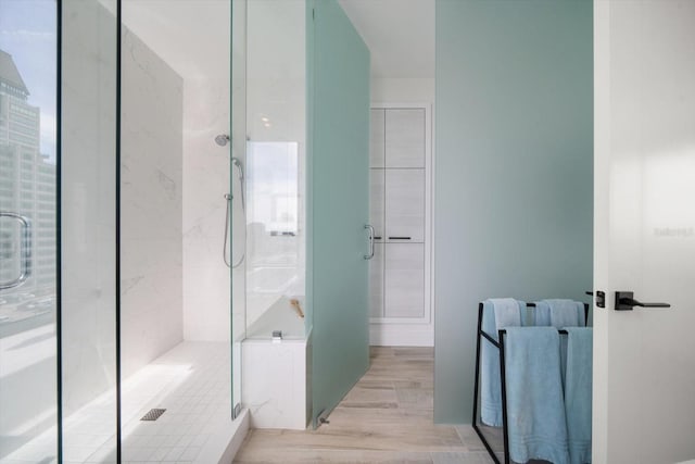 bathroom featuring hardwood / wood-style flooring and a shower with door