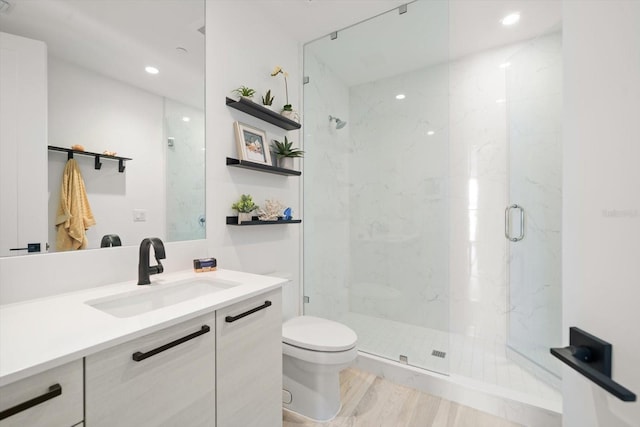 bathroom with vanity, wood-type flooring, an enclosed shower, and toilet