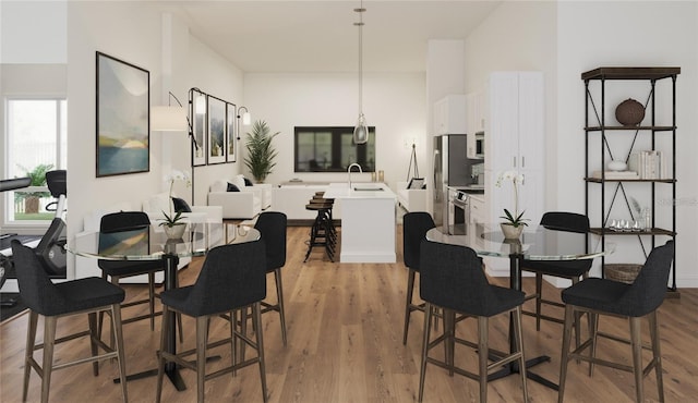 dining space with plenty of natural light, light hardwood / wood-style floors, and sink