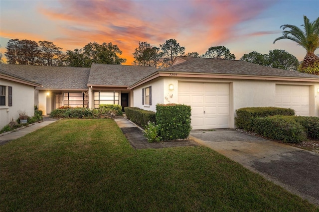 ranch-style home featuring a lawn and a garage