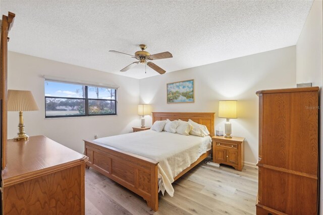 bedroom featuring ceiling fan, a textured ceiling, and light hardwood / wood-style flooring