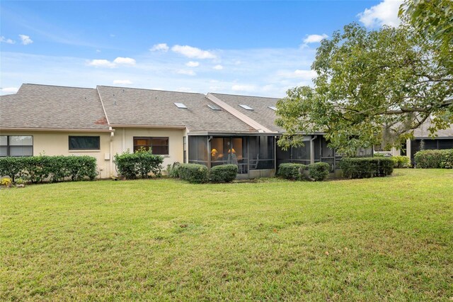 back of house featuring a sunroom and a lawn