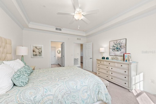 bedroom featuring light carpet, a raised ceiling, ceiling fan, crown molding, and connected bathroom