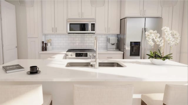 kitchen featuring stainless steel refrigerator with ice dispenser, a kitchen bar, sink, decorative backsplash, and white cabinets