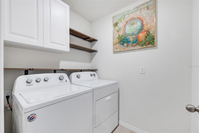 laundry room featuring washing machine and clothes dryer, light tile patterned floors, and cabinets