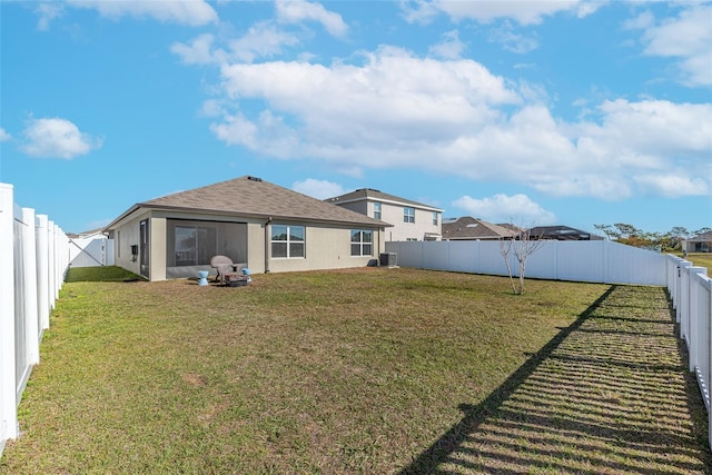 rear view of house featuring a yard and central air condition unit