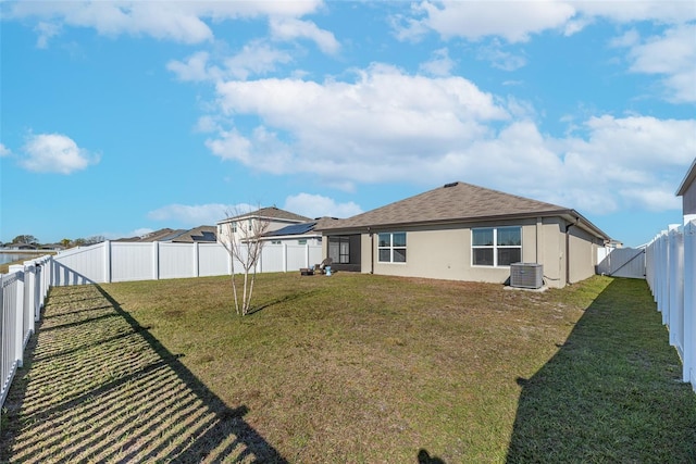 rear view of house featuring a lawn and cooling unit