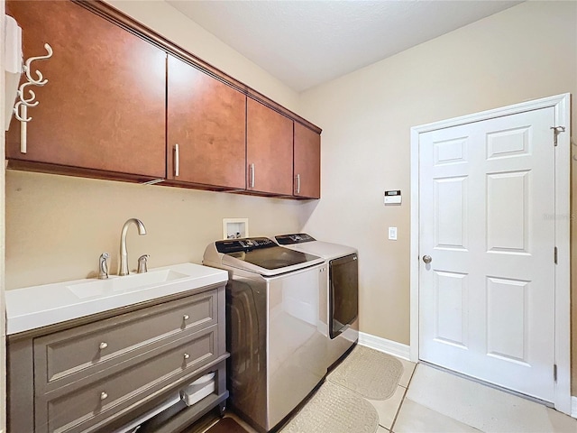 washroom with washer and dryer, sink, light tile patterned flooring, and cabinets