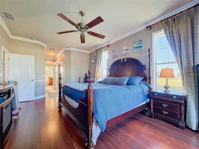 bedroom featuring dark hardwood / wood-style floors, ceiling fan, crown molding, and ensuite bathroom