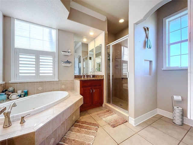 bathroom with tile patterned flooring, vanity, plenty of natural light, and plus walk in shower