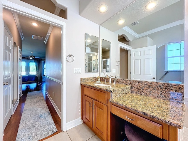 bathroom with vanity, tile patterned floors, crown molding, ceiling fan, and walk in shower