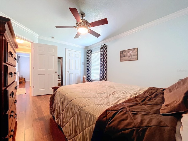 bedroom featuring hardwood / wood-style floors, ceiling fan, and ornamental molding