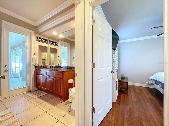 bathroom with vanity, toilet, a wealth of natural light, and ornamental molding