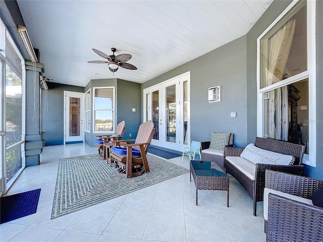 sunroom / solarium with a wealth of natural light, french doors, and ceiling fan