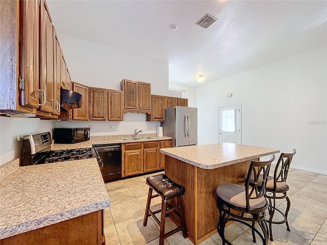 kitchen with a breakfast bar, sink, black appliances, a center island, and light tile patterned flooring