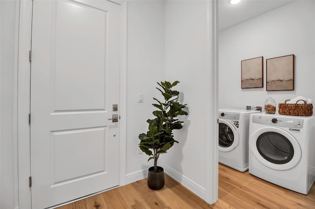 laundry room featuring recessed lighting, laundry area, light wood-type flooring, washing machine and clothes dryer, and baseboards