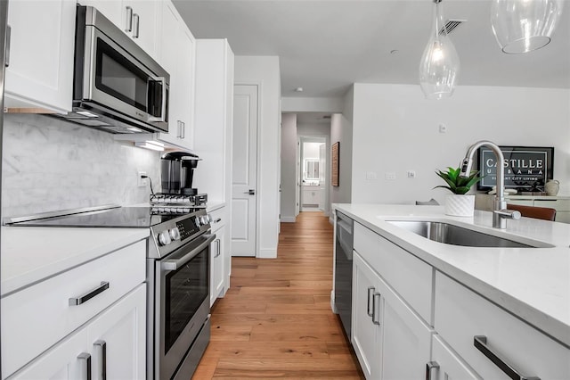 kitchen featuring a sink, light countertops, stainless steel appliances, light wood-style flooring, and visible vents