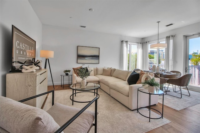 living room with baseboards, wood finished floors, and visible vents