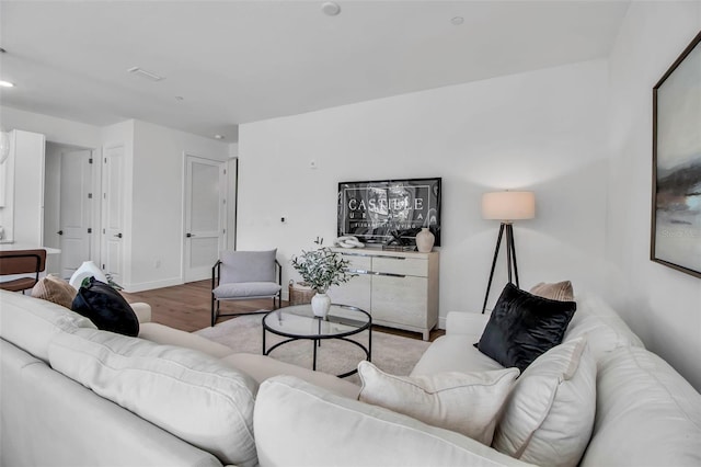 living area with recessed lighting, wood finished floors, and baseboards