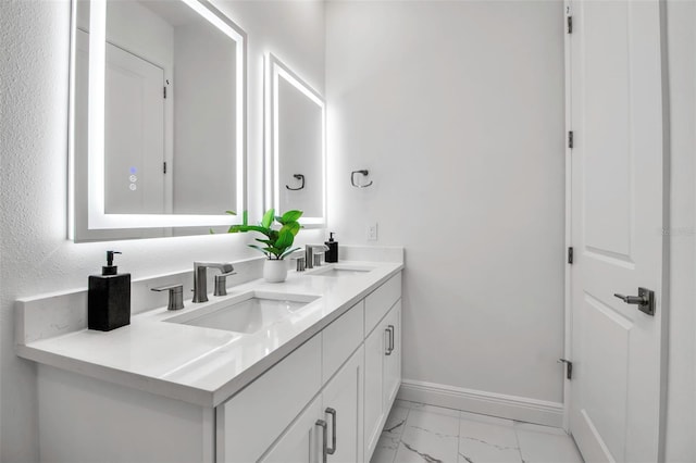 full bathroom with baseboards, marble finish floor, a sink, and double vanity