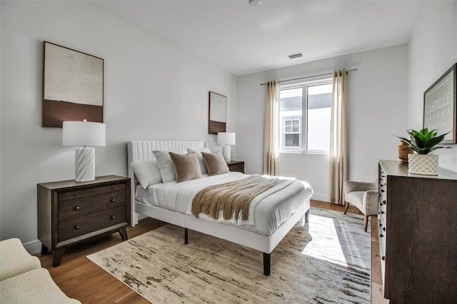 bedroom featuring visible vents and wood finished floors