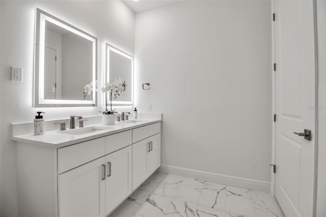 bathroom with double vanity, marble finish floor, baseboards, and a sink