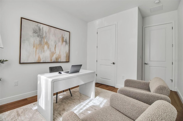 office space featuring baseboards and wood finished floors