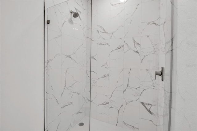 bathroom featuring a marble finish shower