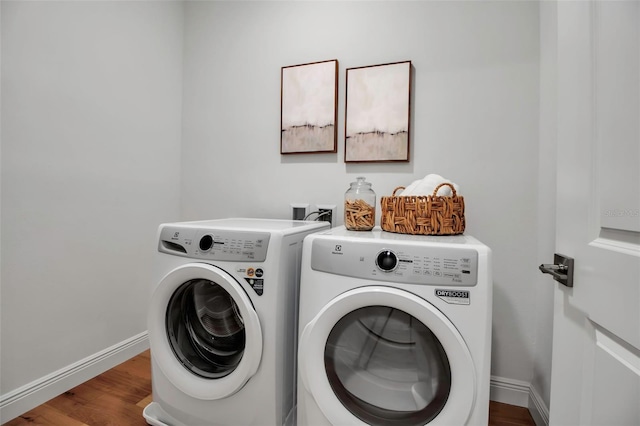 laundry area featuring independent washer and dryer, wood finished floors, baseboards, and laundry area
