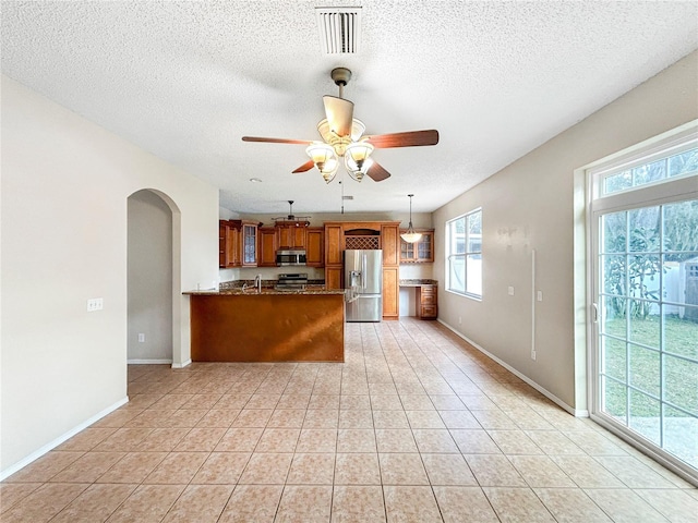 kitchen with kitchen peninsula, ceiling fan, plenty of natural light, and stainless steel appliances