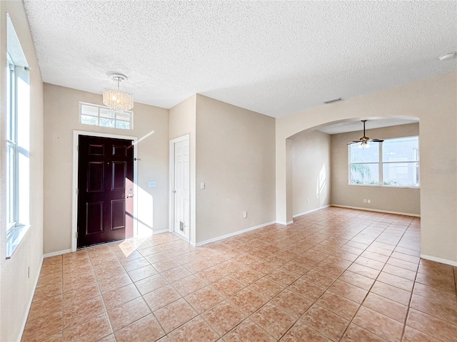 entrance foyer featuring a textured ceiling, ceiling fan, and light tile patterned flooring