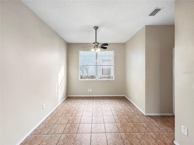 empty room with light tile patterned floors, a textured ceiling, and ceiling fan