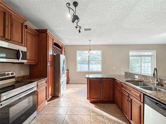 kitchen with pendant lighting, a healthy amount of sunlight, sink, and stainless steel appliances