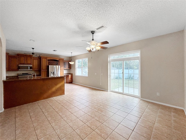 kitchen featuring kitchen peninsula, light tile patterned floors, stainless steel appliances, and ceiling fan