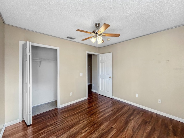 unfurnished bedroom featuring a closet, ceiling fan, dark hardwood / wood-style flooring, and a textured ceiling