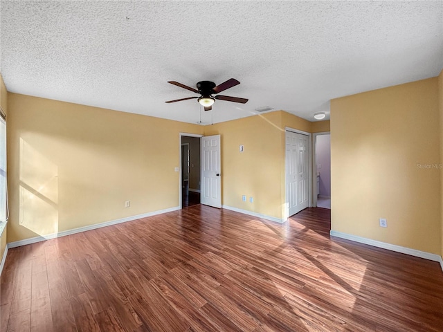 empty room with ceiling fan, a textured ceiling, and hardwood / wood-style flooring