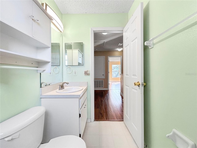 bathroom with vanity, a textured ceiling, and toilet