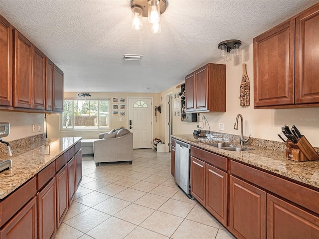 kitchen featuring light stone counters, sink, light tile patterned floors, and dishwasher