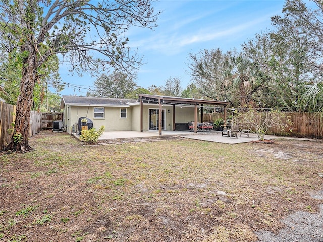 rear view of property featuring a yard, central AC, and a patio