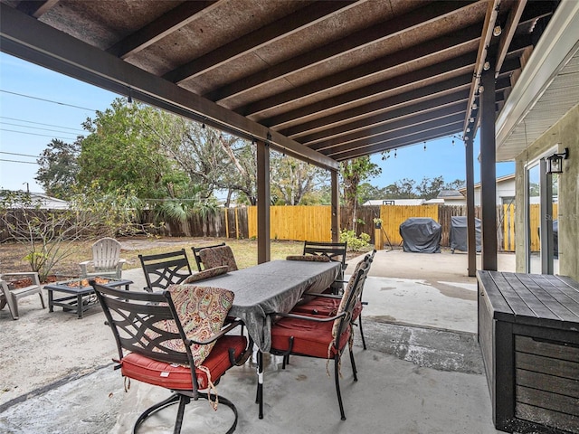 view of patio with area for grilling and a fire pit