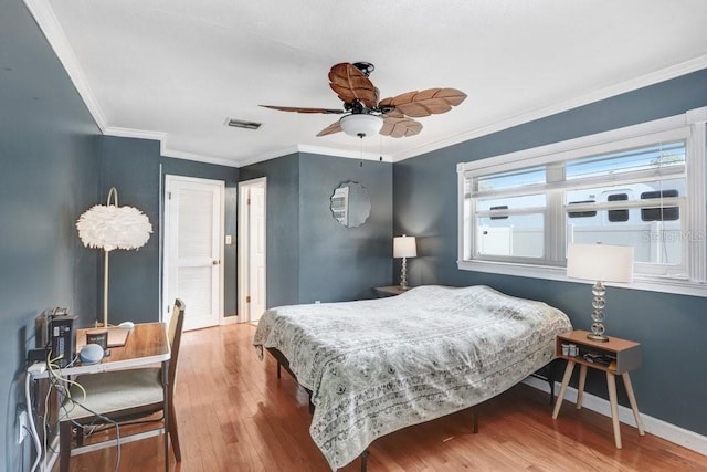 bedroom featuring ceiling fan, hardwood / wood-style floors, and ornamental molding