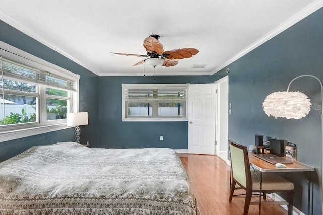 bedroom with hardwood / wood-style floors, ceiling fan, and crown molding