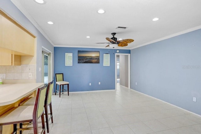 kitchen with backsplash, ceiling fan, crown molding, and light brown cabinetry