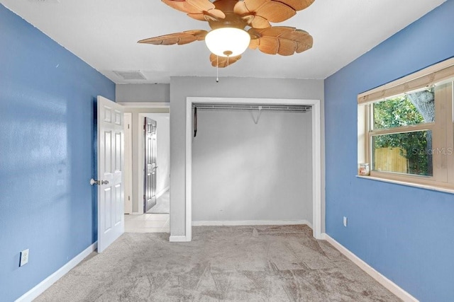 unfurnished bedroom featuring ceiling fan, a closet, and light carpet