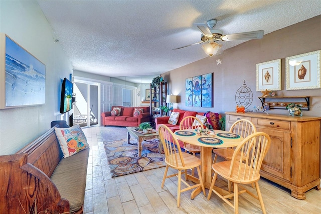 dining area with ceiling fan and a textured ceiling